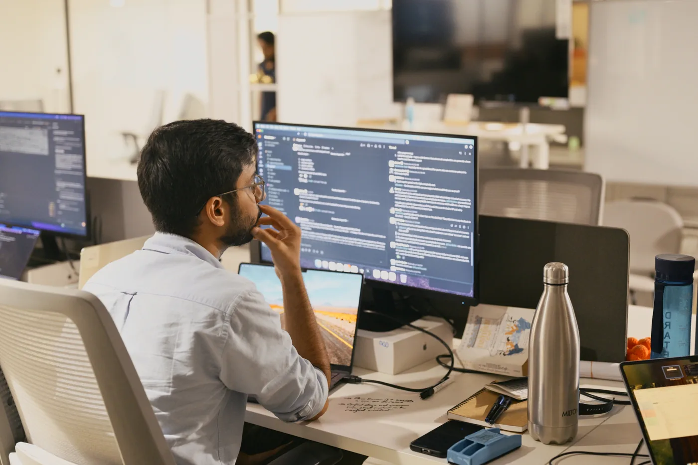 A colleague reading through code at their desk