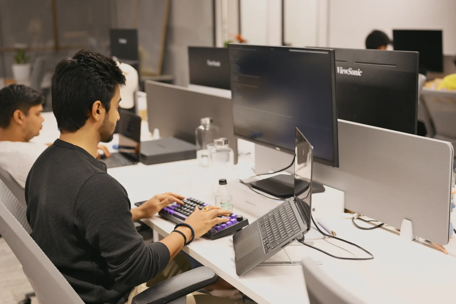 A colleague at a desk of monitors, mid-build