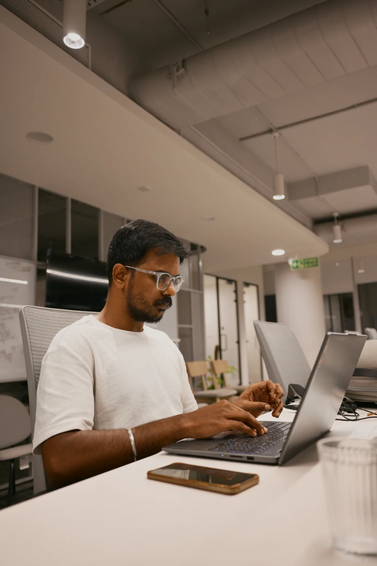 A colleague working at a laptop in the open-plan office