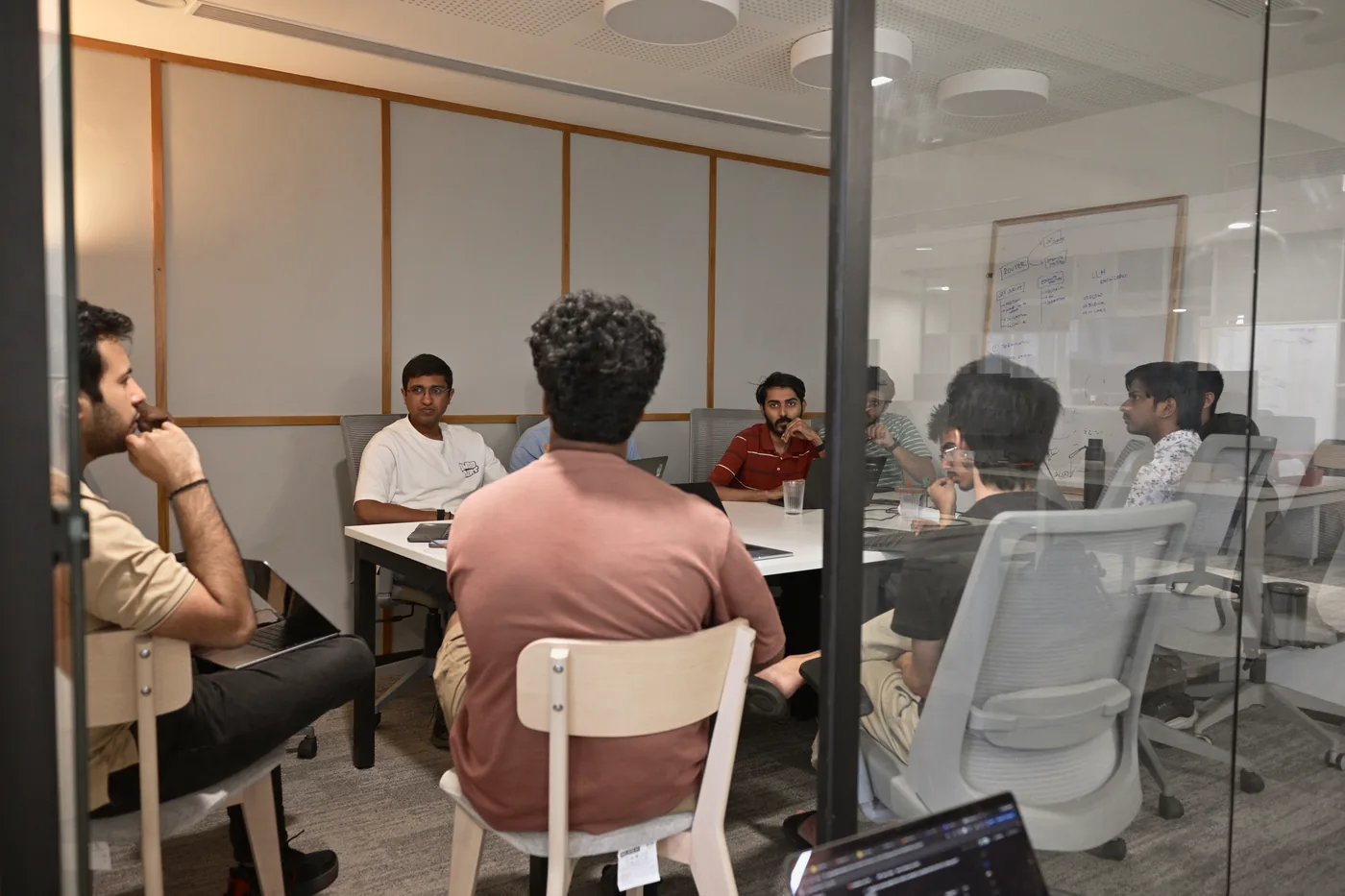 A team meeting, seen through the glass wall of a meeting room